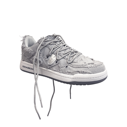 The DABE RANGER TWENTYTWO GREY shoe, a streetwear statement piece with metallic details under denim fabric on the upper. The shoe features double laces for extra style and versatility. Each shoe is handmade and unique, with every hole made by hand, giving it a one-of-a-kind look. The shoe is perfect for those who want to stand out from the crowd and make a fashion statement.